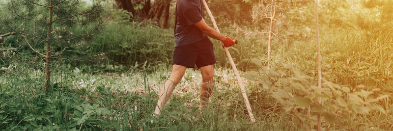 Mowing grass with hand scythe on household farm. farmer man mowing weed of farmland with scythe.