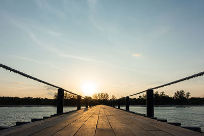 Bridge over river against sky during sunset