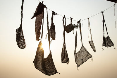 Close-up of clothes drying on rope against sky