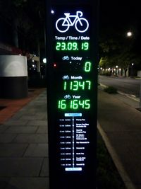 Information sign on road in city at night