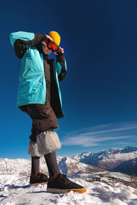 Rear view of man standing on snow