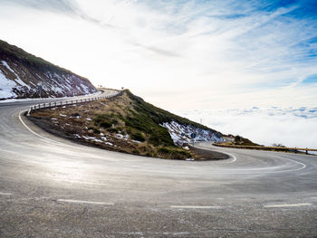 Empty road by mountain against sky