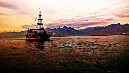 Boats sailing in sea at sunset