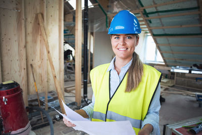Portrait of confident manual worker analyzing document at construction site