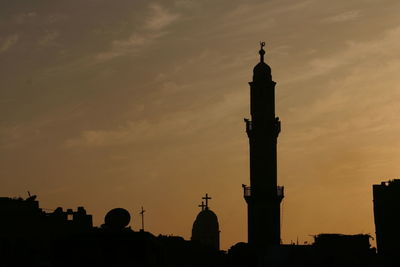 Low angle view of silhouette buildings against sky at sunset