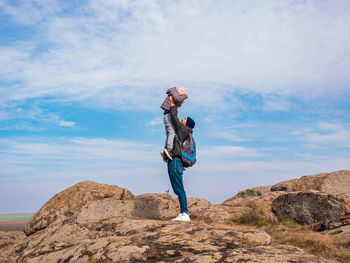 Travelers father daughter walking climbing mountain summit enjoying aerial view cloudy sky together