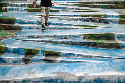 Low section of man walking on steps