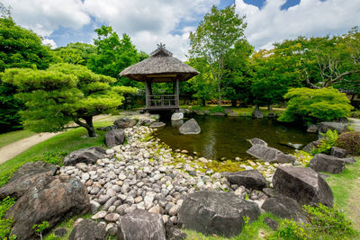 Gazebo by lake against sky