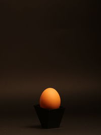 Close-up of egg on table against black background