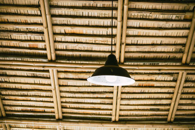 Low angle view of illuminated pendant light hanging on ceiling