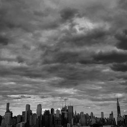 Modern cityscape against cloudy sky