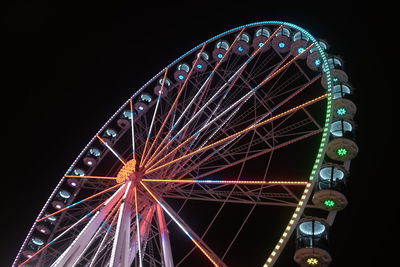 Low angle view of illuminated ferris wheel against sky at night