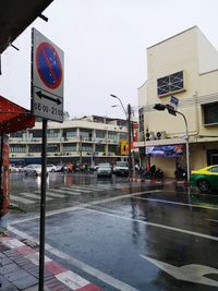 Road sign on wet street in city