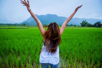 Woman standing in farm against sky