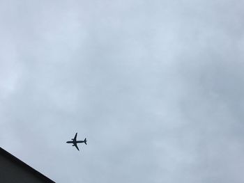 Low angle view of airplane in flight against sky