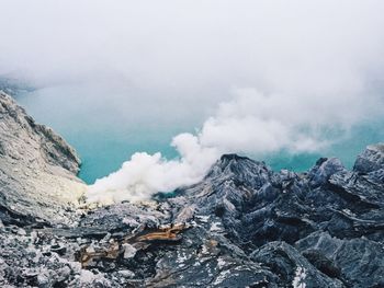 Smoke emitting from volcanic mountain against sky