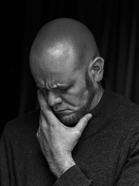 Mid age man looking away against black background