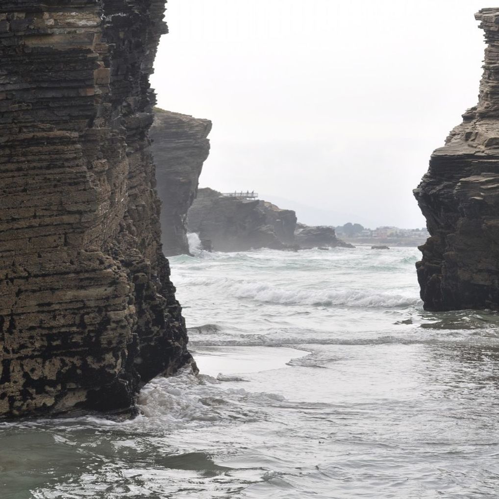 sea, water, rock formation, rock - object, scenics, beauty in nature, tranquil scene, tranquility, cliff, nature, horizon over water, waterfront, wave, rock, clear sky, sky, idyllic, surf, beach, coastline