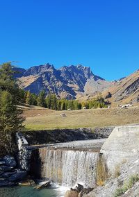 Scenic view of dam against blue sky