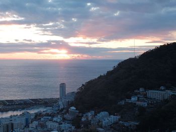 High angle view of townscape by sea against sky during sunset