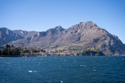 Scenic view of sea and mountains against clear sky