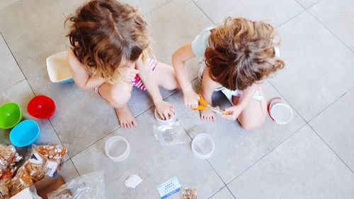High angle view of girls playing on floor at home