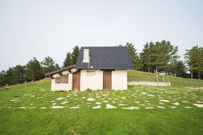 House on field against clear sky