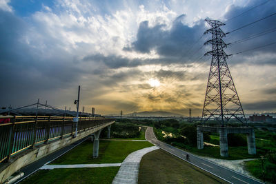 Bridge over road against sky during sunset