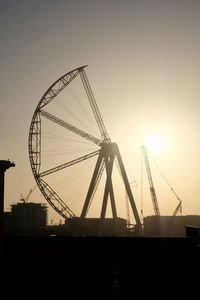 Low angle view of silhouette ferris wheel against sky during sunset