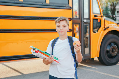 Kid standing by bus on street