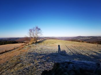 Scenic view of field against clear blue sky