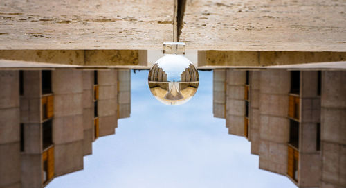 Low angle view of light bulbs hanging from building