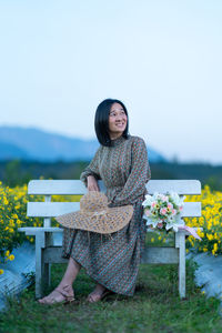 Portrait of smiling young woman against plants