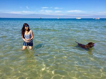 Woman in sea against sky