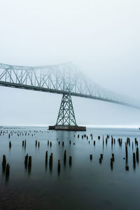 Low angle view of bridge over river during foggy weather