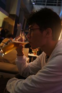 Side view of young man drinking beer in restaurant