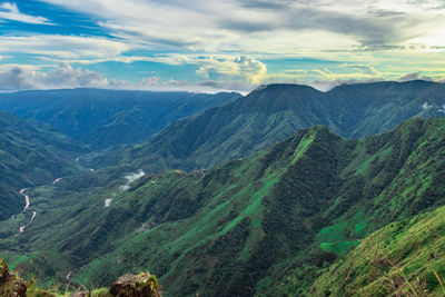 Mountain valley covered with green forests and bright blue sky at morning