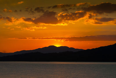 Scenic view of silhouette mountains against romantic sky at sunset