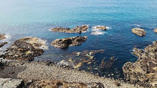 High angle view of rocks on sea shore