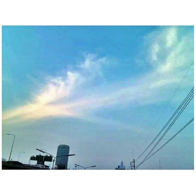 transfer print, low angle view, sky, auto post production filter, power line, cloud - sky, electricity pylon, power supply, electricity, cloud, fuel and power generation, built structure, technology, cloudy, connection, building exterior, cable, blue, silhouette, architecture