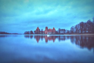 Calm lake with buildings in background