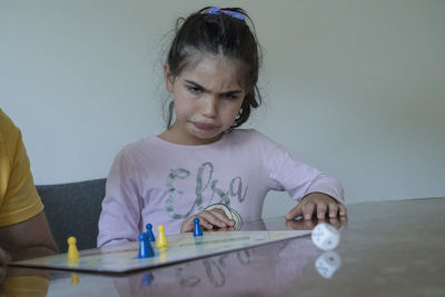 Rear view of girl looking at table