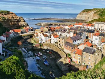 High angle view of townscape by sea against sky