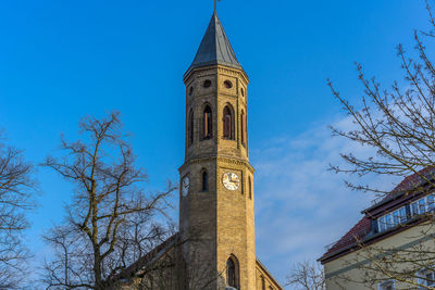 Low angle view of bell tower against blue sky