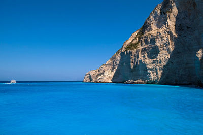 Scenic view of cliff by sea against sky