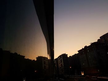 Silhouette city against sky during sunset