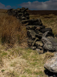 Stack of rocks on field against sky