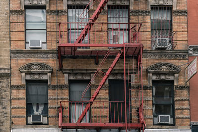 Low angle view of building in lower manhattan with red iron fire escape