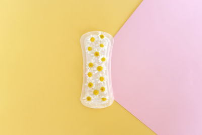 A sanitary pad with chamomile flowers on it lies on a colorful background. menstruation days. 