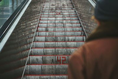 Rear view of person standing against escalator in subway station